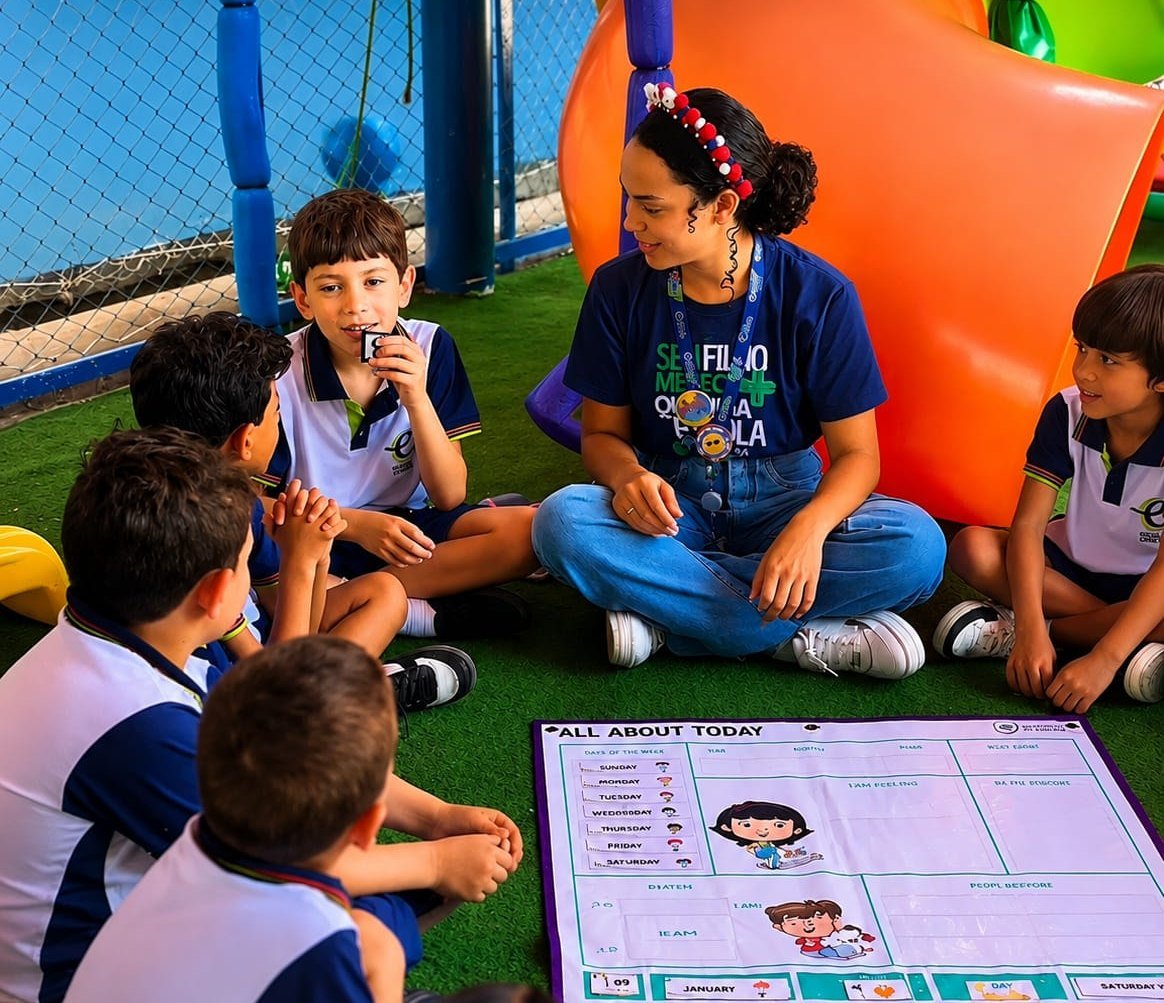 Turma em aula do Programa Bilingue com o quadro All About Today na area externa da escola